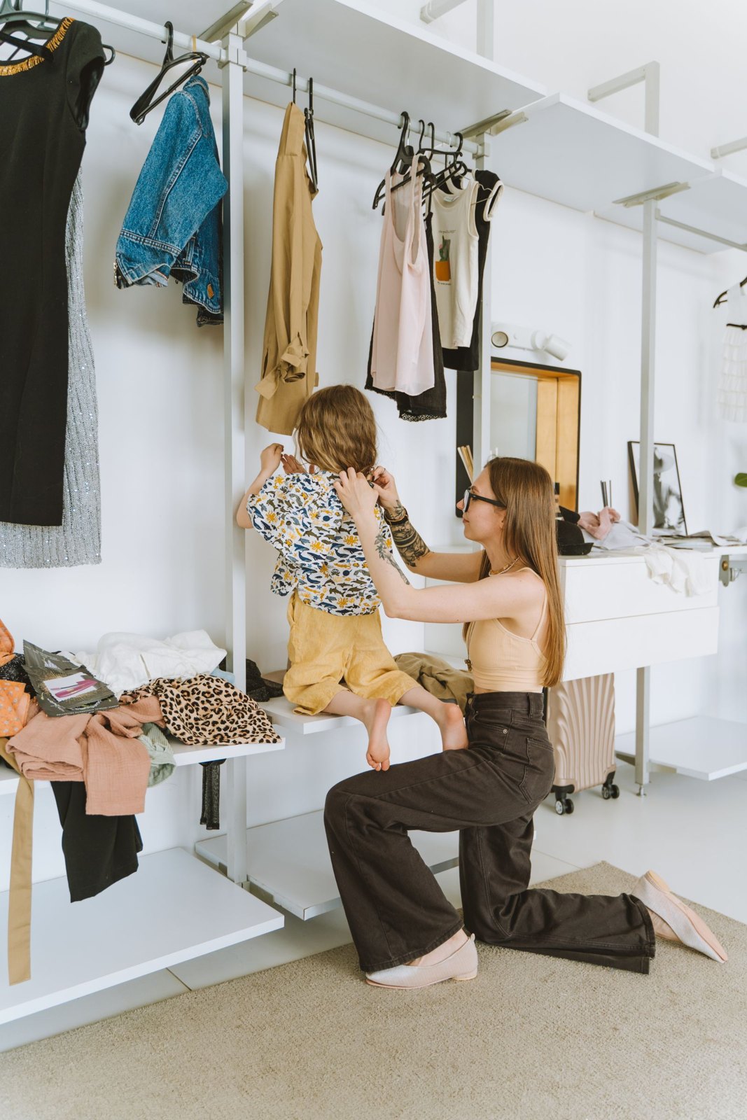A woman dressing her child