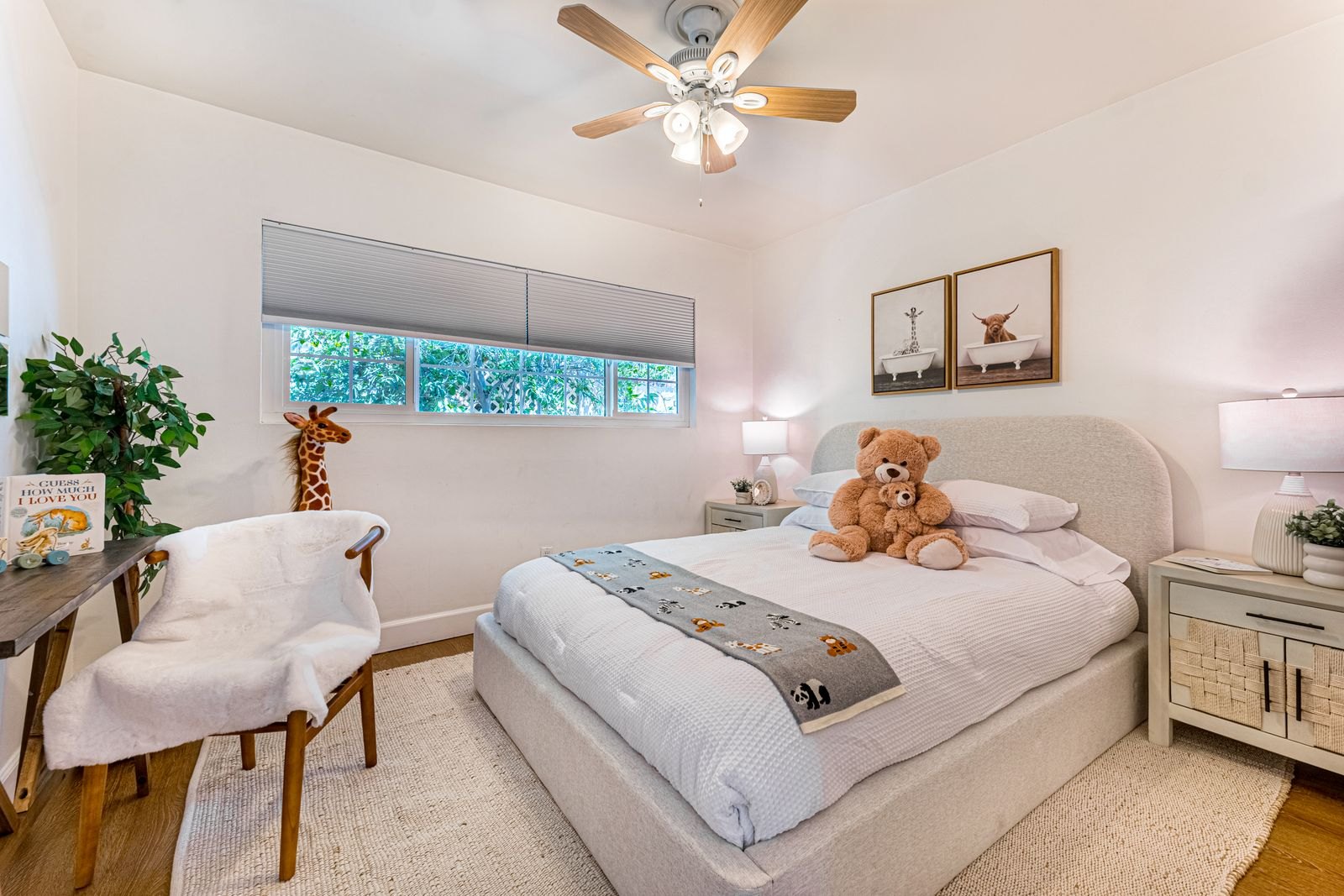 A bedroom with a white bed and a teddy bear