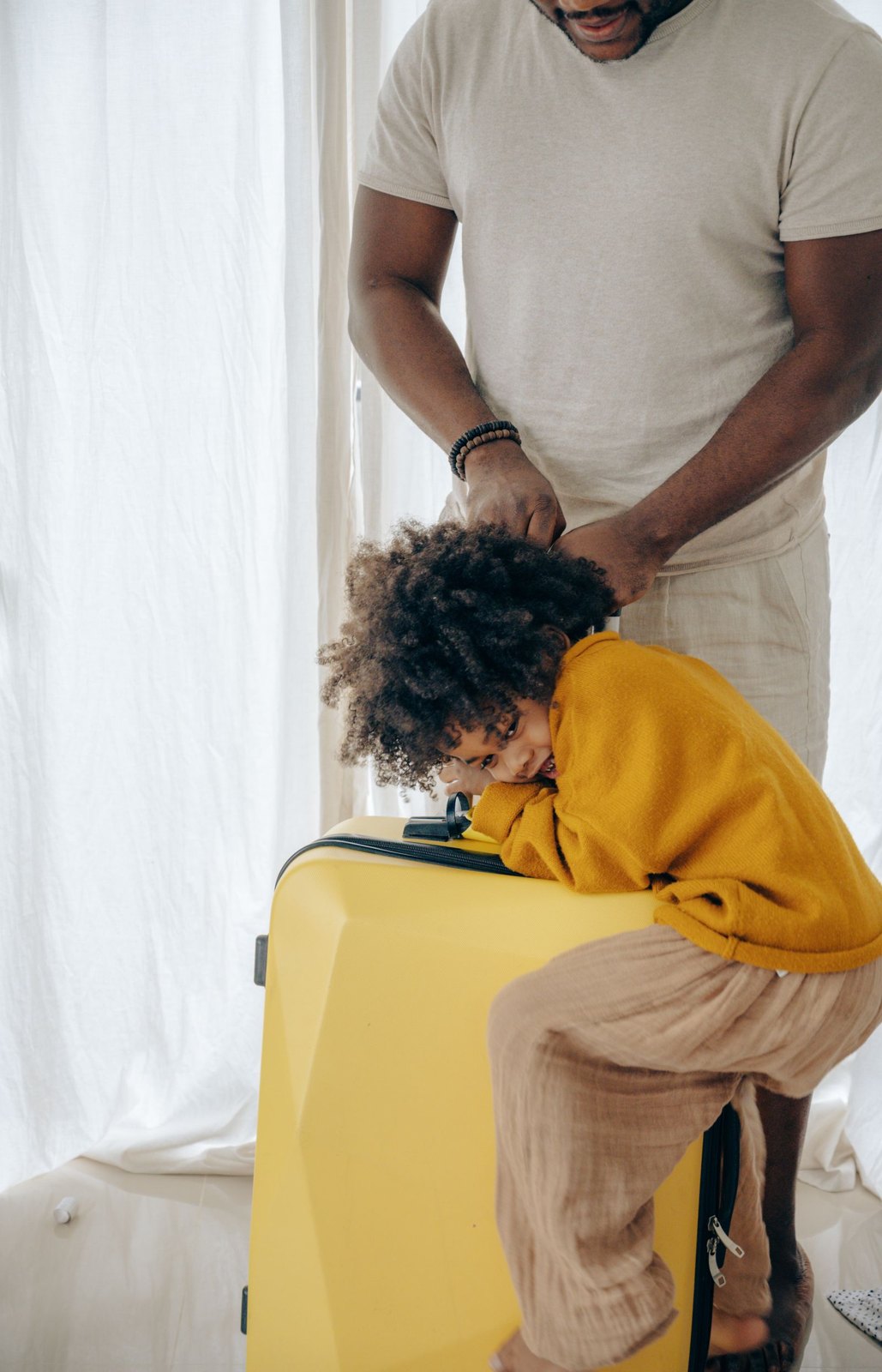 Parent and child beside a suitcase
