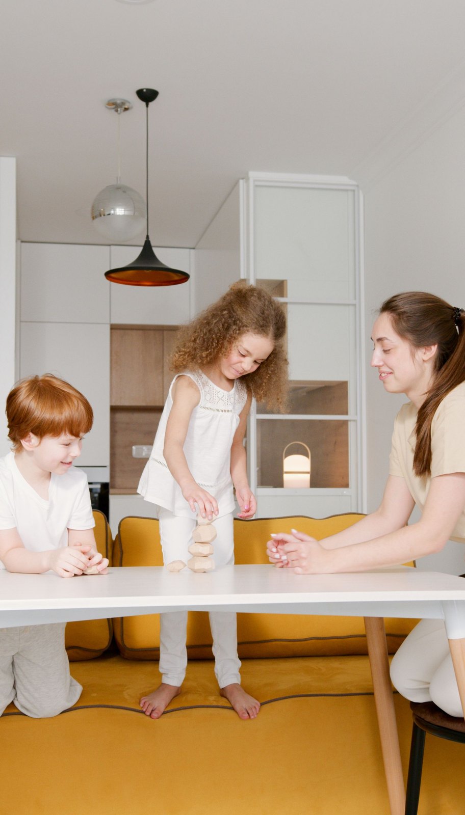 Two children and their mother playing with wooden blocks