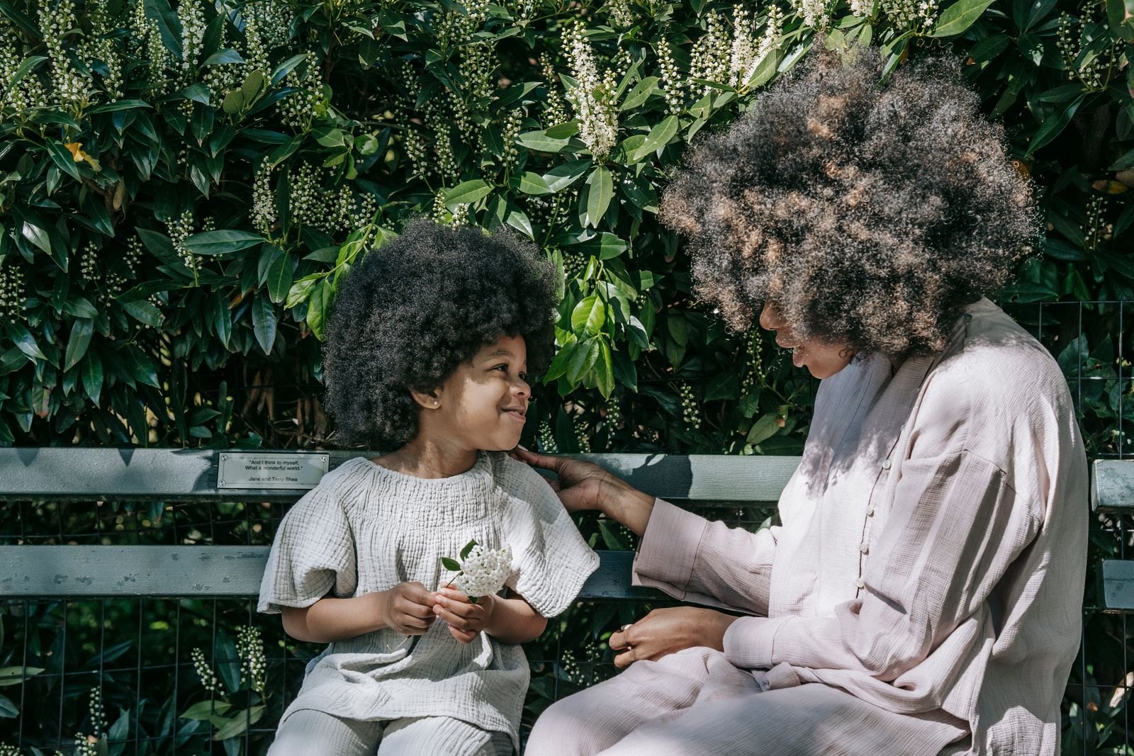 A mother talking to her child while sitting on a bench