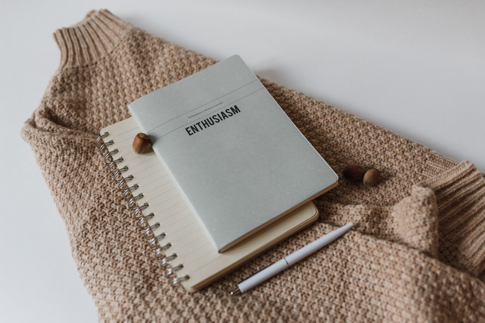 Notebook and pen resting on a folded sweater