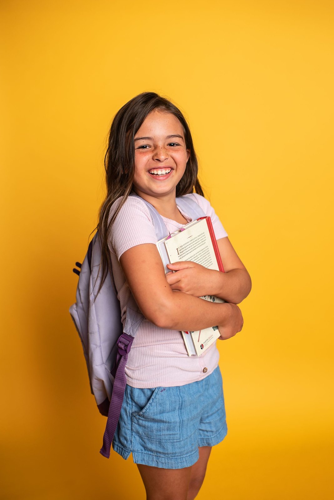 Smiling schoolgirl holding book