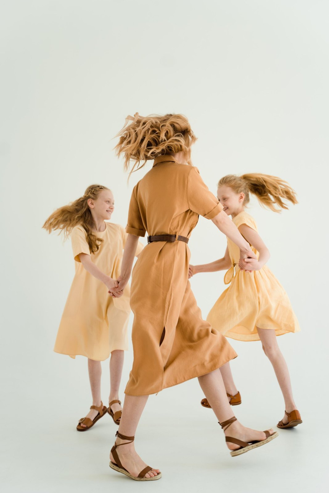Mother and children holding their hands and dancing