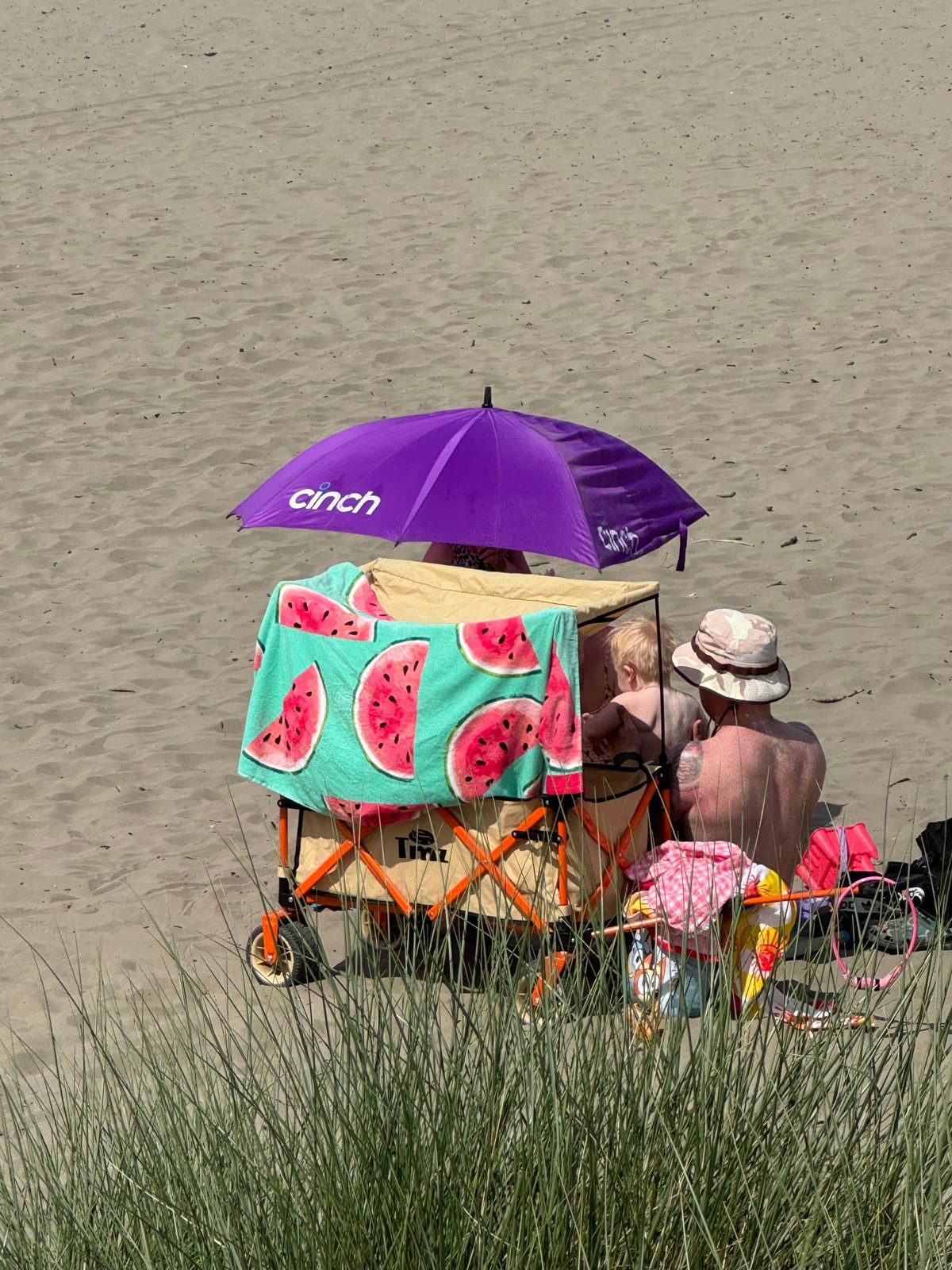 Family beach outing under vibrant umbrella