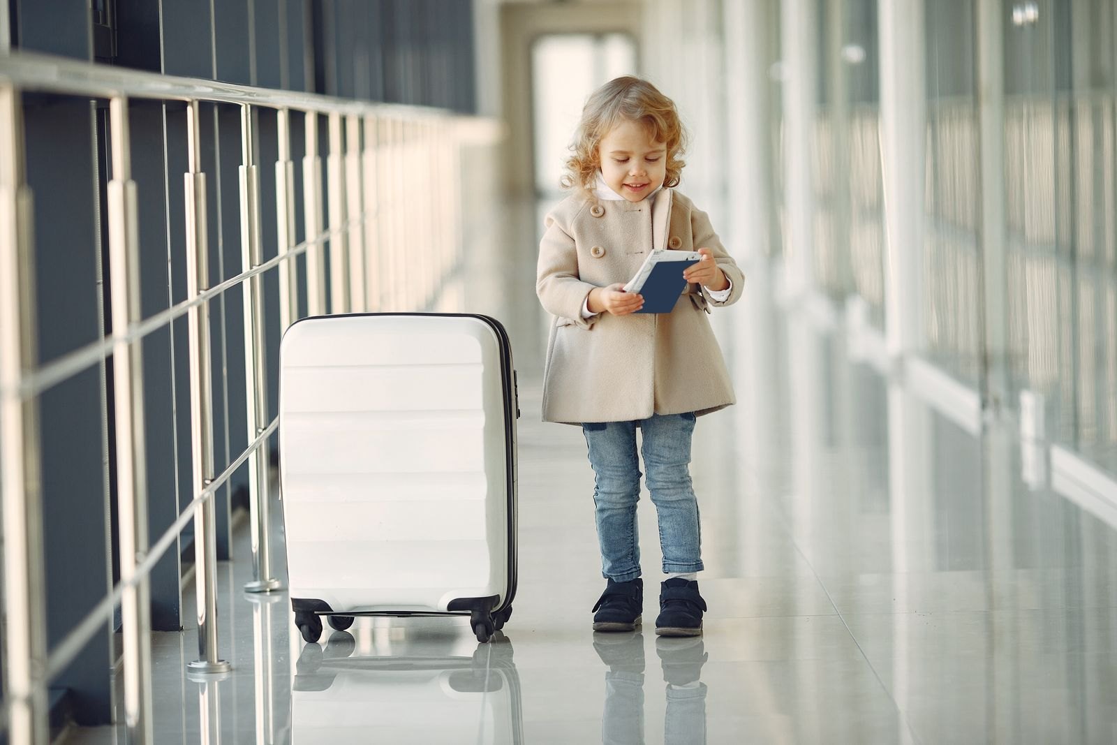 Child with a suitcase in an airport corridor