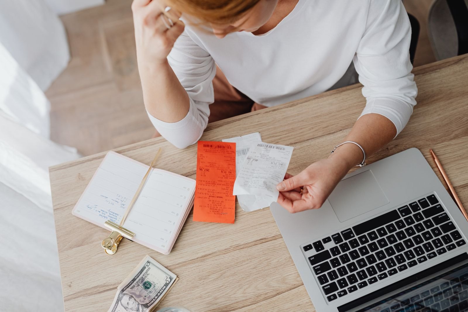 Woman sitting behind the desk and looking at receipts